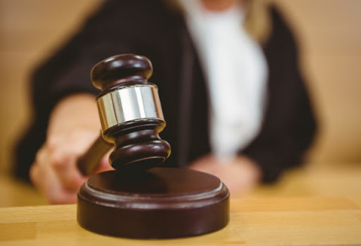 Hand about to bang gavel on sounding block in the court room